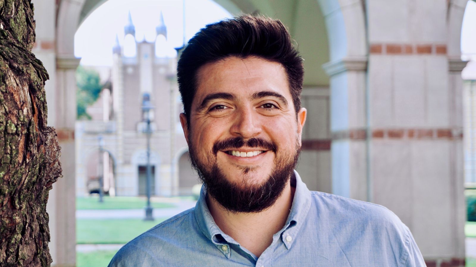 Man with beard stands outside on Rice University campus