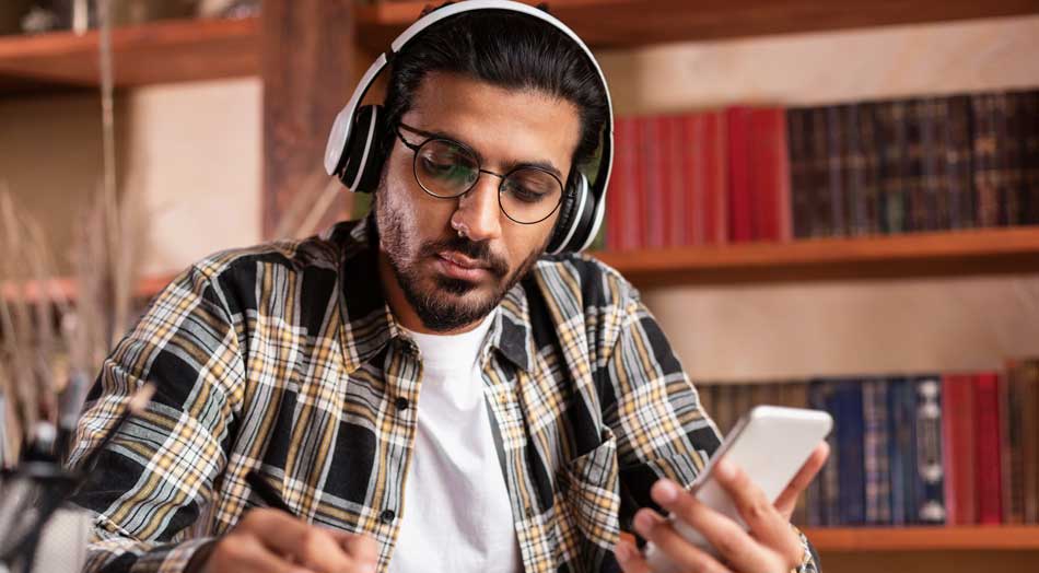 Graduate student taking online courses on iPhone at local library