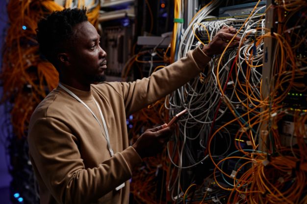 a man in the server room fixing the wires 